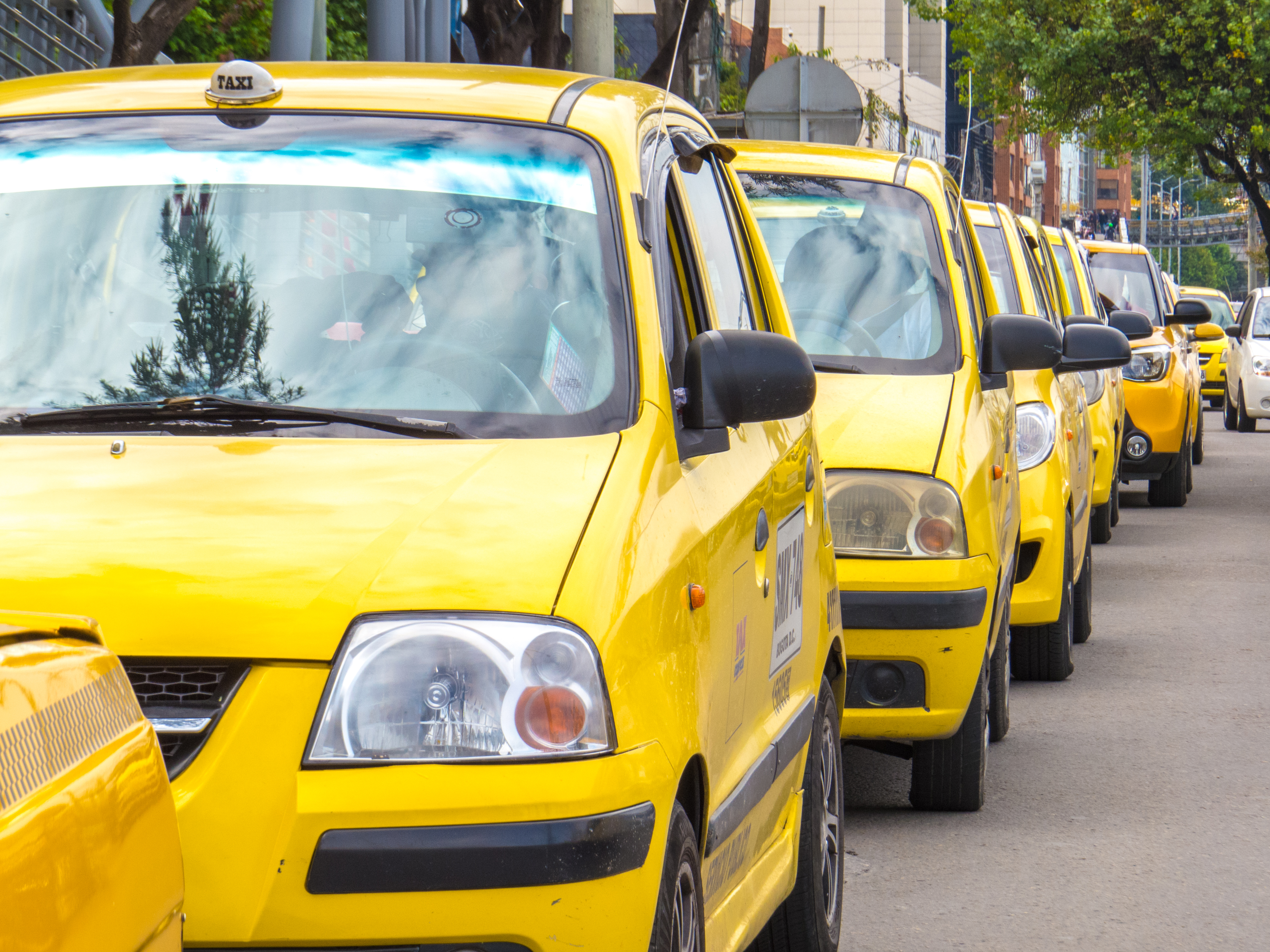 Fila de taxis amarillos listos para operar en la ciudad